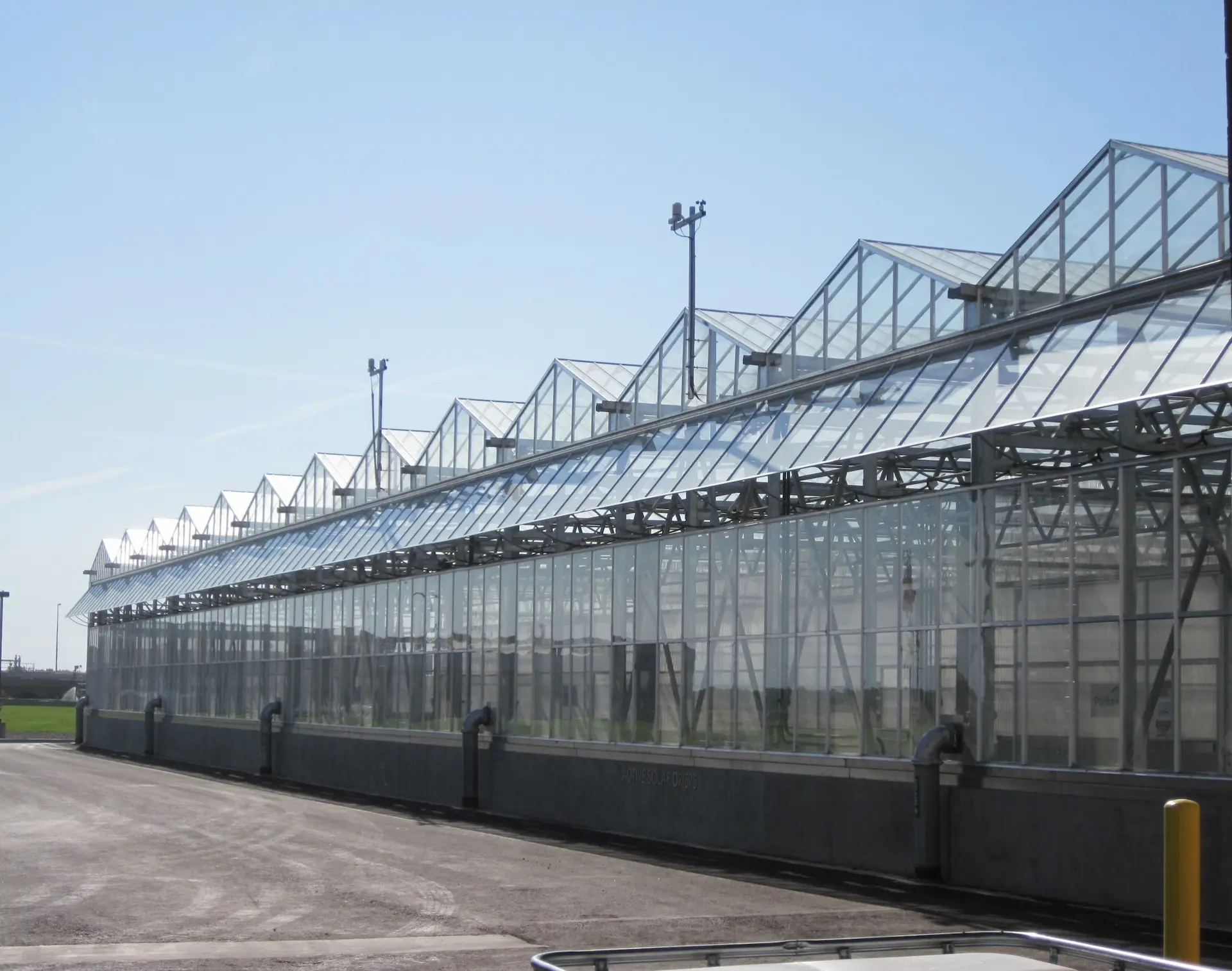 High-tech multi-span glass greenhouse system for modern agriculture by EcoHarvest.